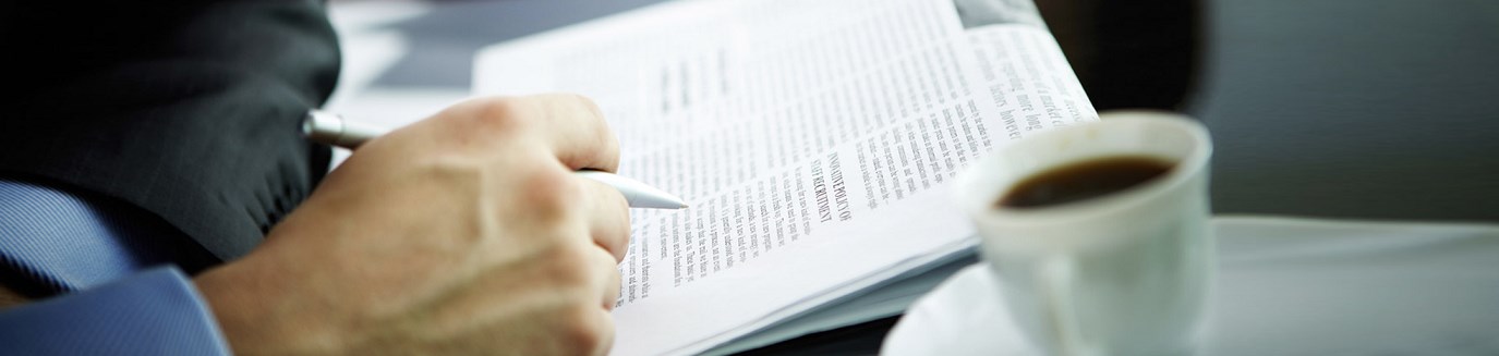 Executive reviewing a business report over a cup of coffee
