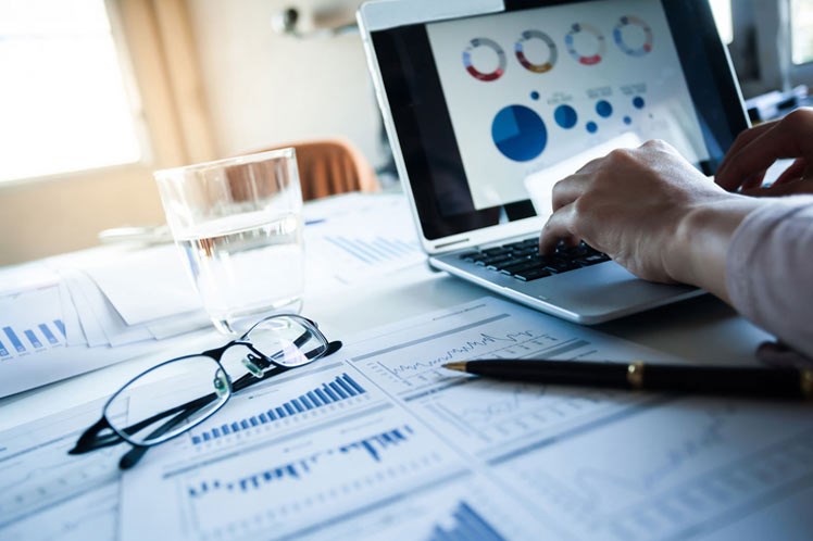 Financial charts and a laptop showing business performance analytics